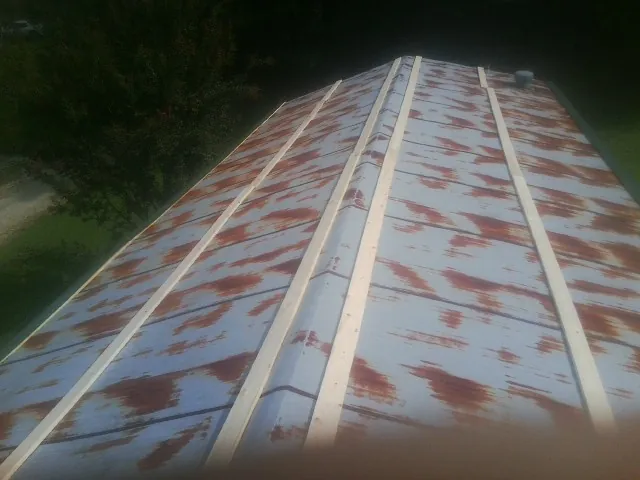 Rusted metal roof panels with new wood purlins before replacement — Storm Damage Roof Repair in Day by Roofing Brothers