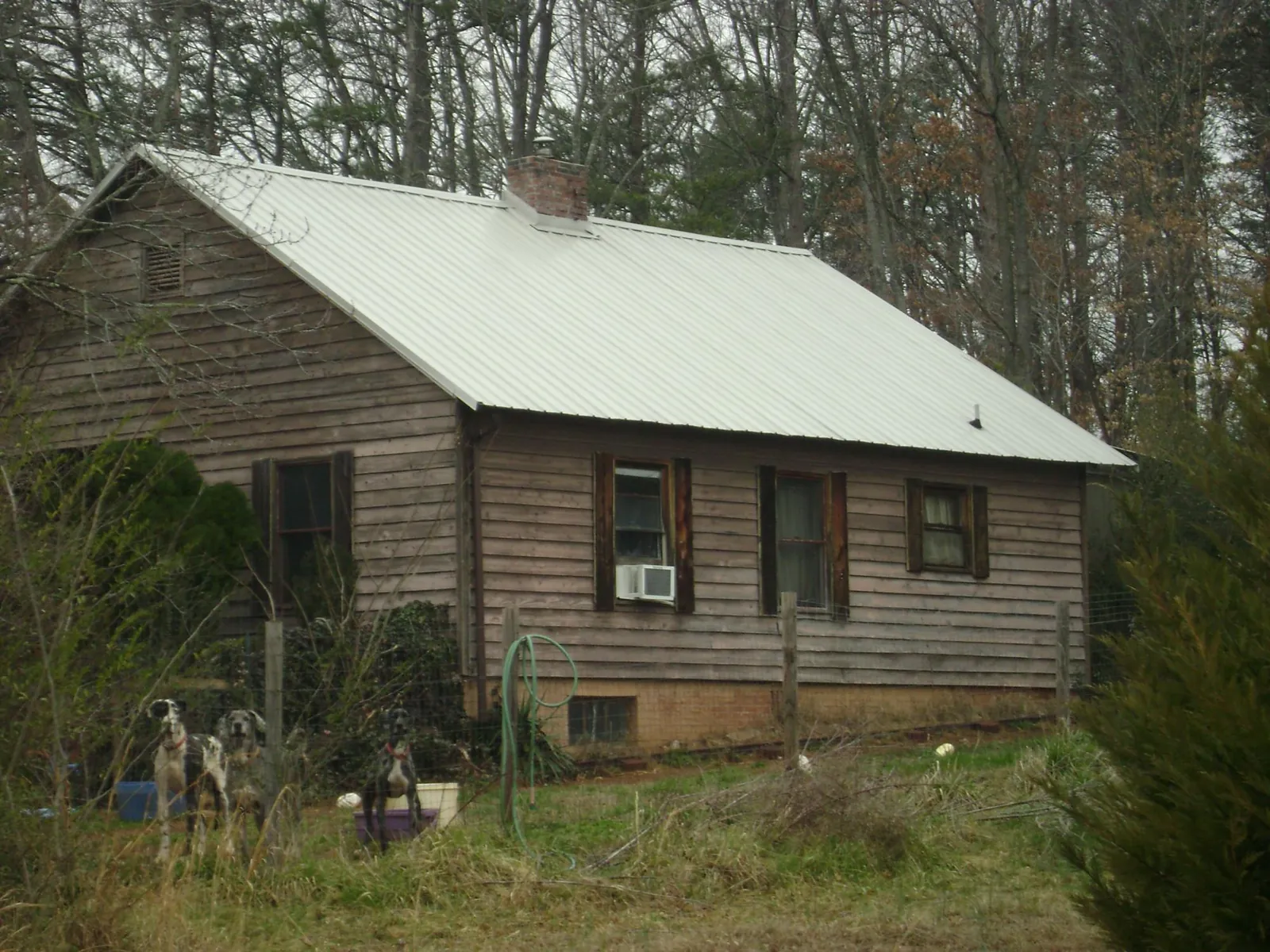 White metal roof on an old wood sided farmhouse, from a Metal Roof Installation job in Day